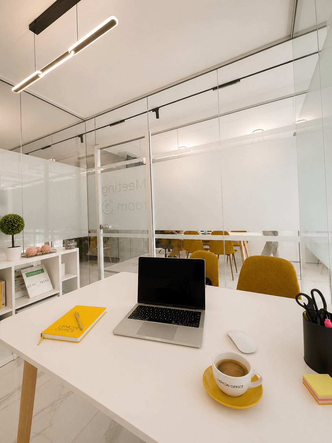 Pracovné miesto v kancelárii Office 2 s notebookom, firemnými doplnkami a presklenými kancelárskymi priestormi LemonOffice.
